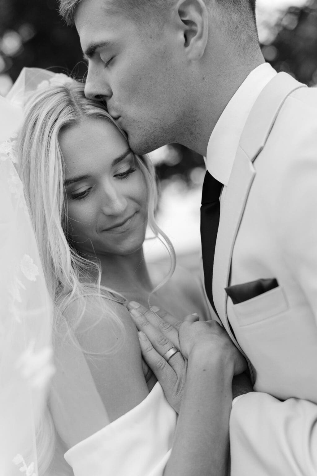 black and white closeup photo of bride and groom embracing